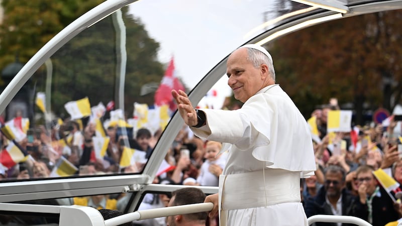 Pope Leo XIV waves to the crowd on the Champs Elysees avenue before a mass at the Place de la...