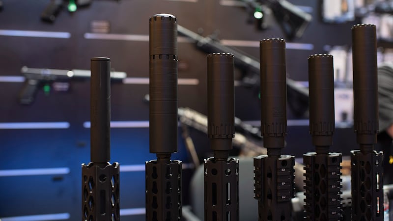 FILE - Firearms and suppressors are displayed at SHOT Show, the annual trade show for the gun...