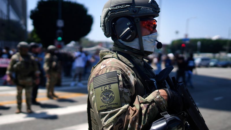 Un agente del ICE observa una manifestación contra las redadas migratorias frente al Centro de...
