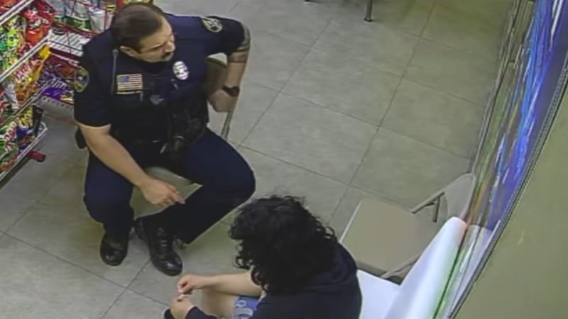 Officer Marco Rodriguez sits with distressed teen