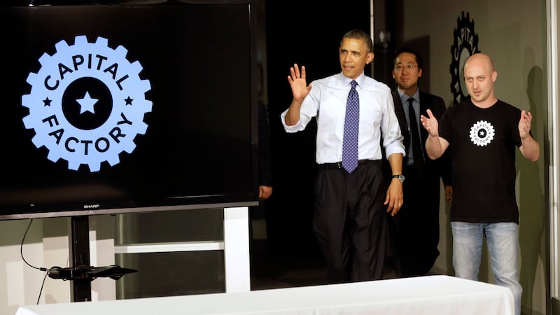 President Barack Obama, center, visits Capital Factory, a tech start-up incubator and...