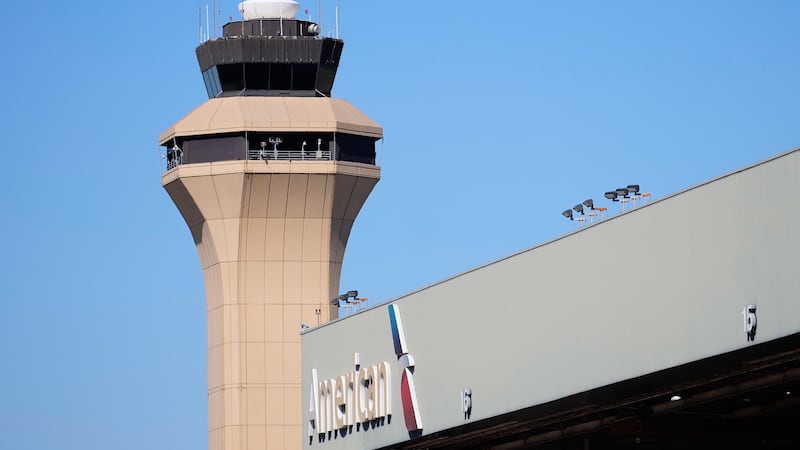 FILE - A control tower by an American Airlines hangar is shown at Dallas Fort Worth...