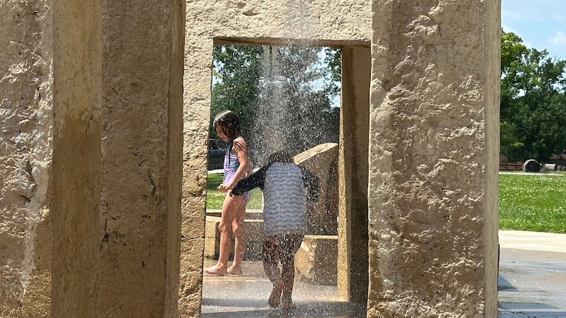 Varios niños juegan en un parque de fuentes brotantes en Des Moines, Iowa, el lunes 29 de...