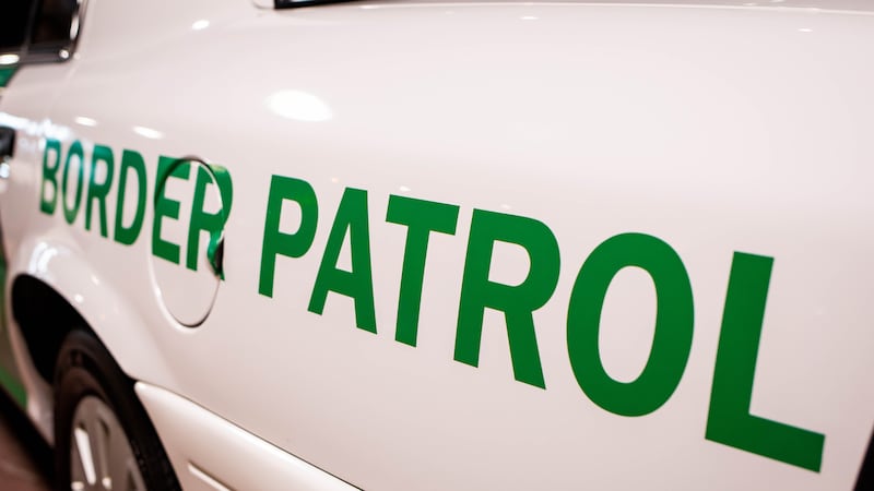 Customs and Border Patrol logo on the side of a patrol car.