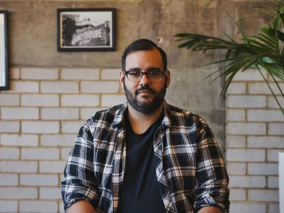 A man with a beard and glasses wearing a plaid shirt.