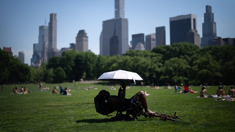ARCHIVO Una persona usa una sombrilla para protegerse del sol durante una advertencia de...